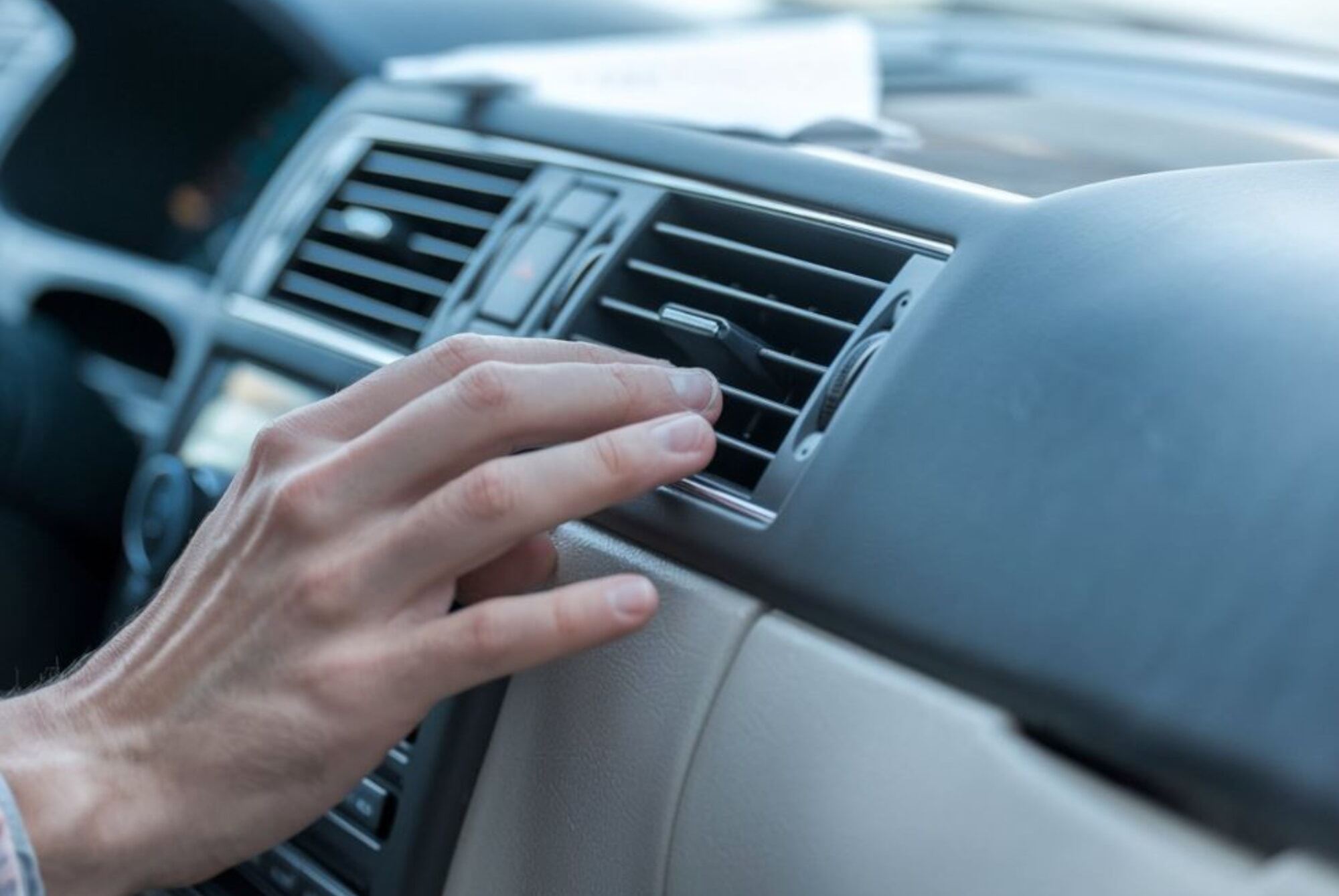 Air Conditioning Services hand on dash